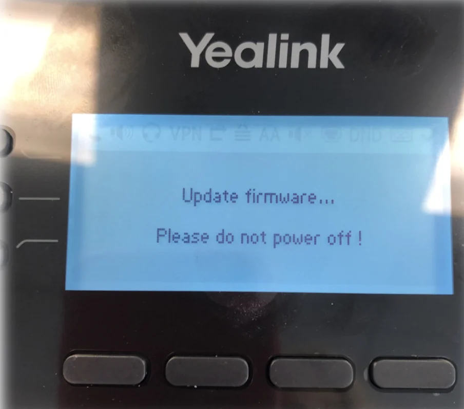 Yealink phone screen showing the firmware update and auto-provisioning process in progress
